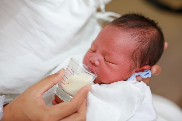 premium-photo-newborn-baby-drinking-milk-from-glass-cup