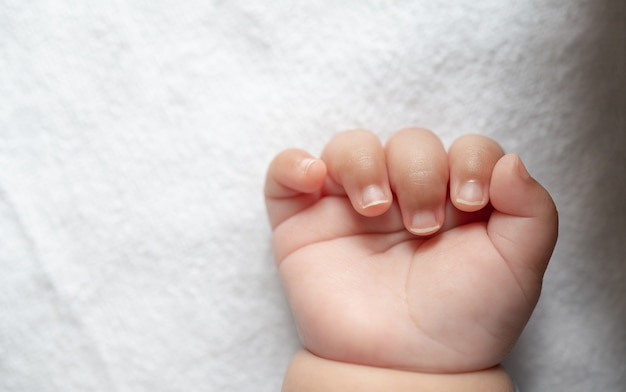 白いベッドで生まれたばかりの赤ちゃんの手 無料の写真