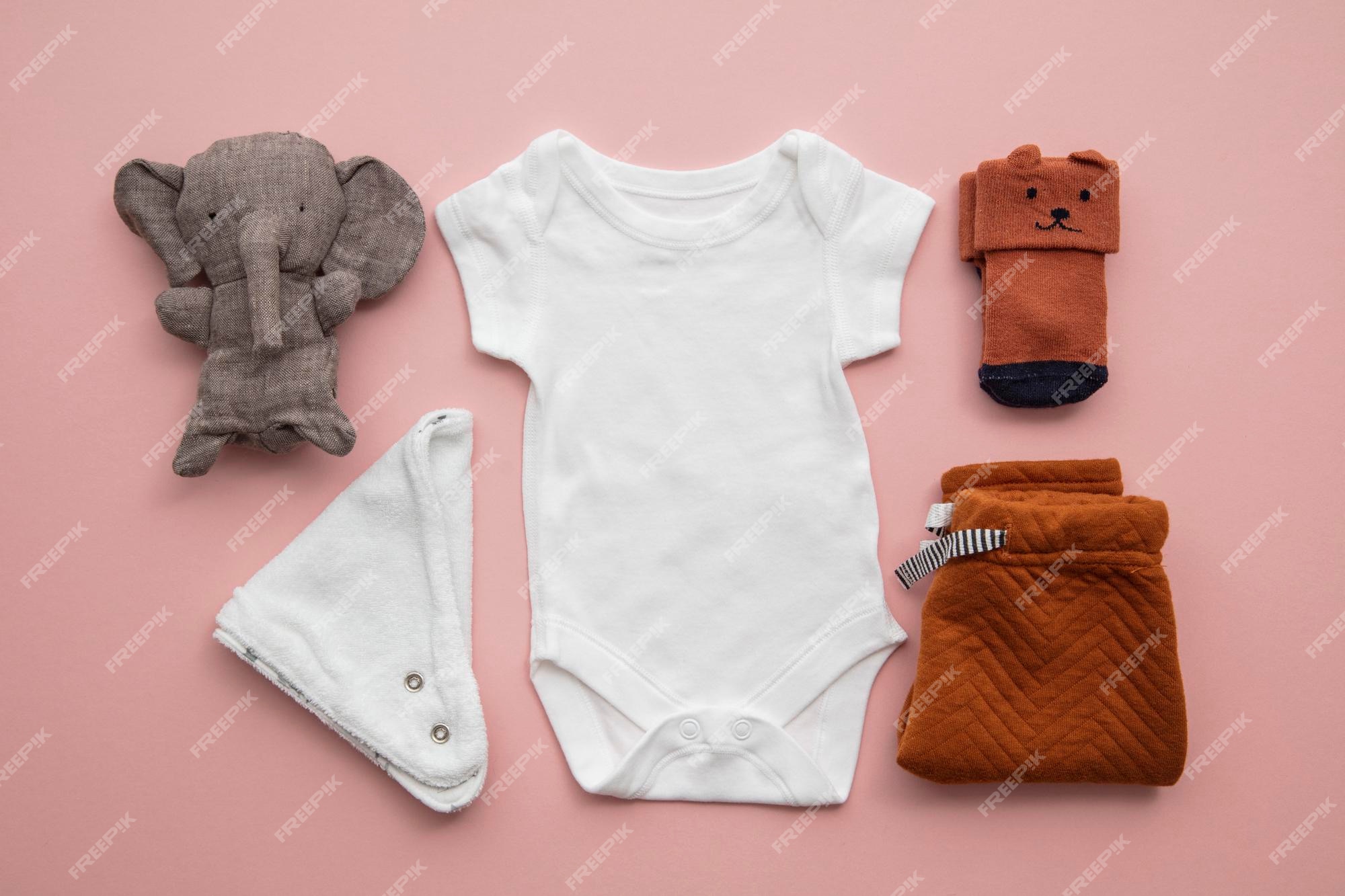 Premium Photo | Newborn child clothing layout on a pastel pink background