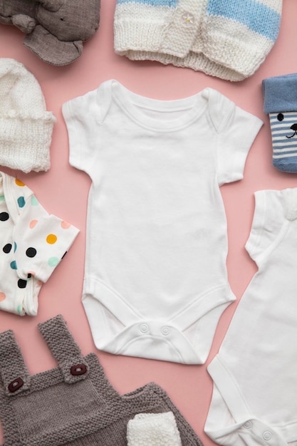 Premium Photo | Newborn child clothing layout on a pastel pink background