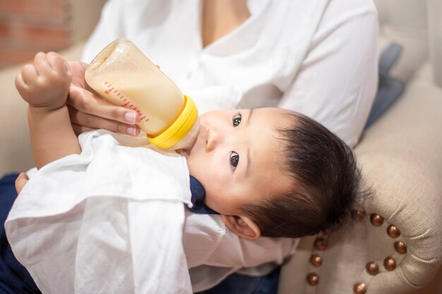 Premium Photo Newborn Cute Baby Is Drinking Milk From Bottle By Mom