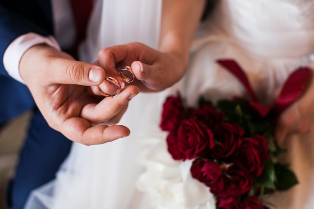 Premium Photo Newlywed Couple Holding In Their Fingers Two Wedding Rings Groom And Bride