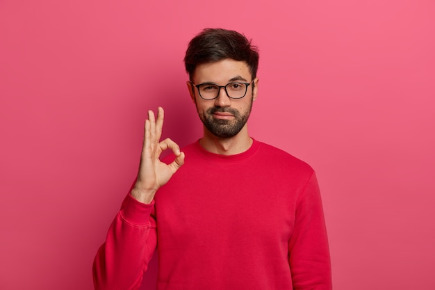 man with glasses doing ok sign