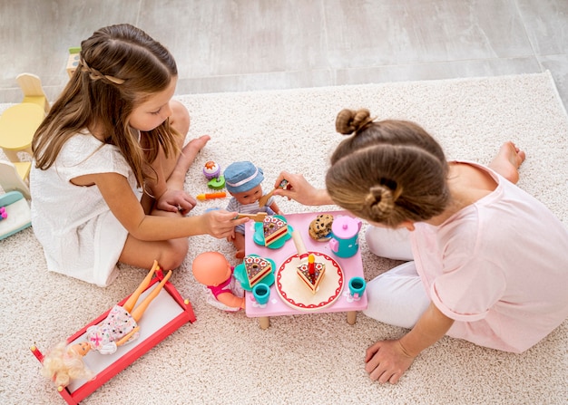 赤ちゃん人形で誕生日ゲームをしている非バイナリの子供たち 無料の写真