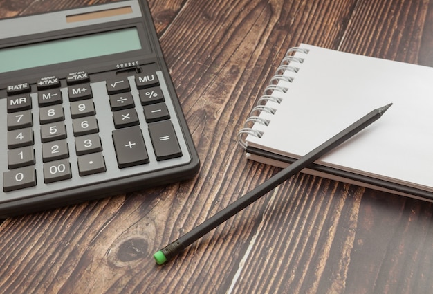 Premium Photo | Notebook and calculator on wooden table