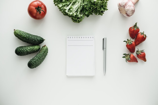 Premium Photo | Notebook with pen and vegetables on a table