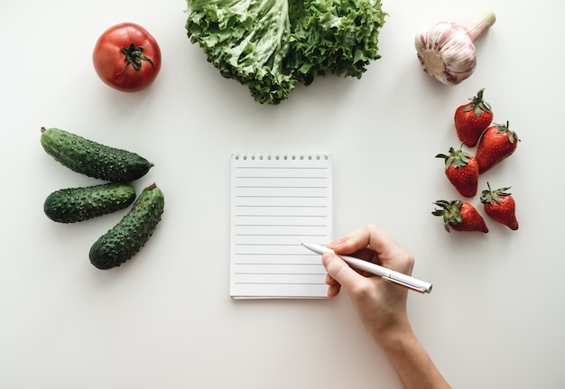 Premium Photo | Notebook with pen and vegetables on a table