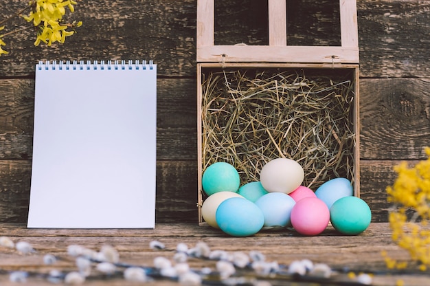 Premium Photo | Notepad mockup with easter eggs and flowers. against ...