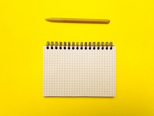 Premium Photo | Notepad and pencil for writing on a yellow surface