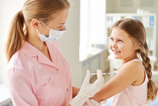A girl receiving vaccine in the medical office. | Photo: Freepik