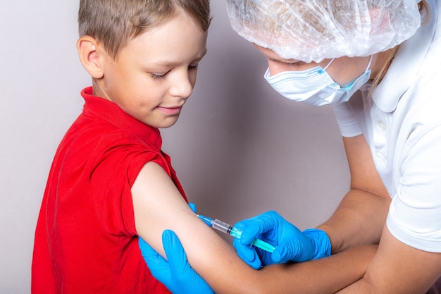 Premium Photo | A nurse injects the vaccine through a syringe into the ...