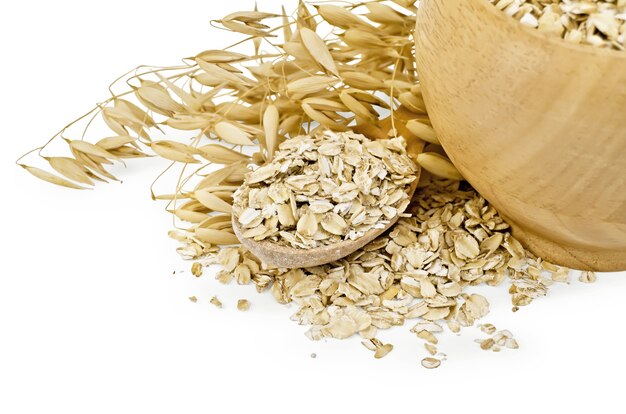 Premium Photo | Oaten flakes in a wooden bowl and spoon, stalks of oats ...