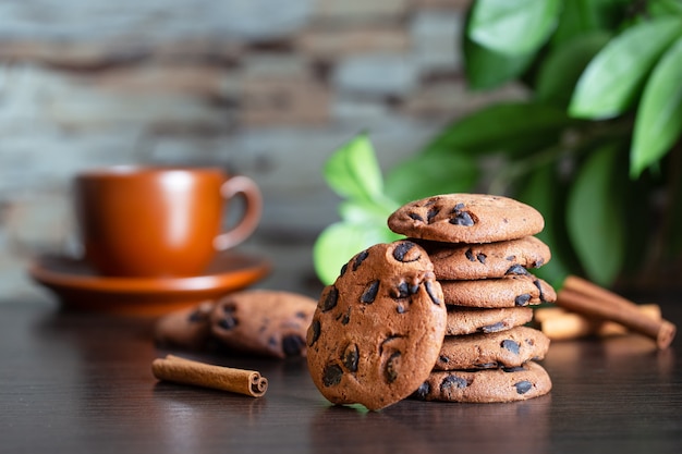 https://image.freepik.com/free-photo/oatmeal-cookies-with-chocolate-on-the-table-against-the-background-of-a-cup-of-coffee-and-green-leaves-breakfast-or-morning-coffee-concept_159938-2970.jpg