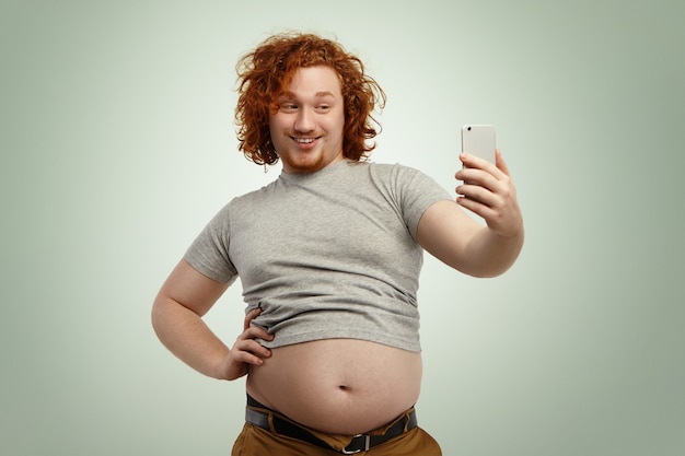 Free Photo Obese Young Male With Curly Ginger Hair And Beard Holding