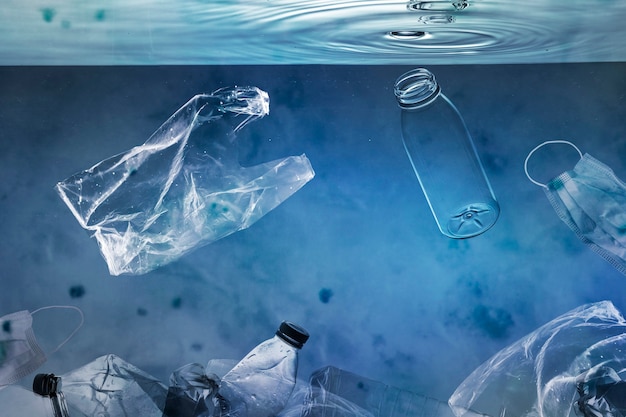 Ocean pollution campaign with plastic bags and used bottles floating Free Photo