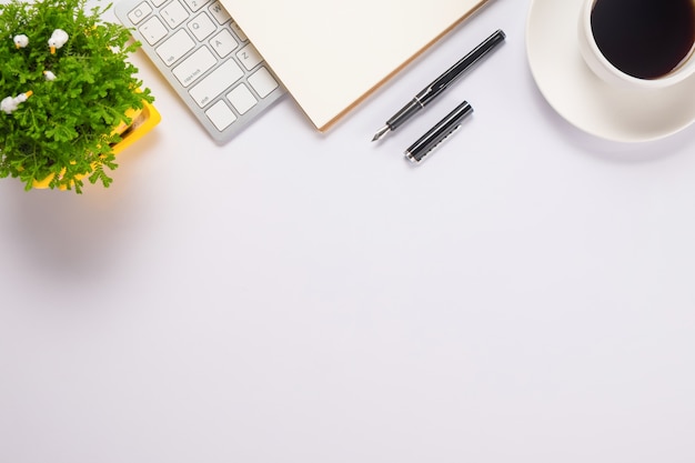 Download Office desk table with pen, keyboard on notebook, cup of ...