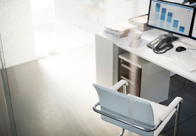 Office workspace with computer desktop showing analysis graph Free Photo