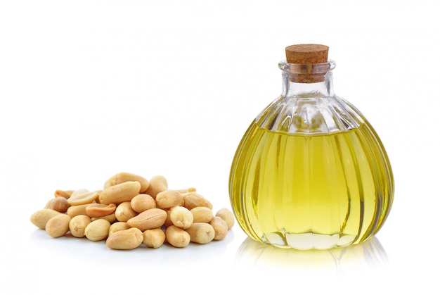 Premium Photo | Oil bottle and peanuts on white space