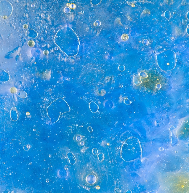 Free Photo | Oil bubbles floating on blue water surface