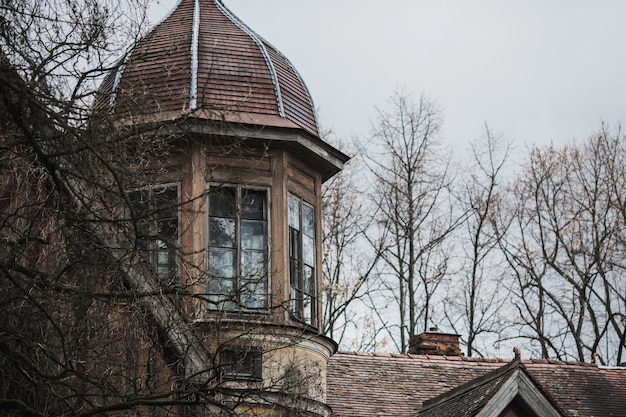 Premium Photo Old Abandoned Gothic House The Ruined Mansion Stands In Park Mysterious Window Gothic Background Halloween Party Place Scary House Window And Roof Of Old Palace Frightening Medieval Building