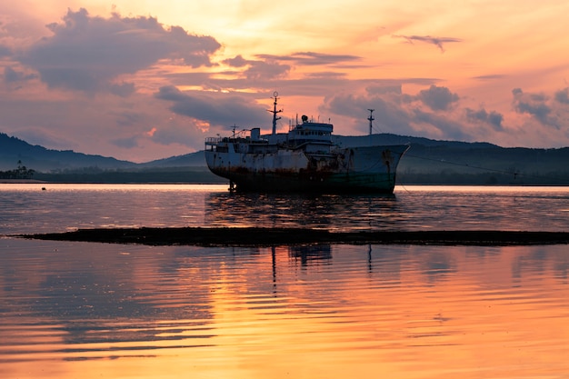 プーケットタイの海の美しい日の出の古いボート プレミアム写真