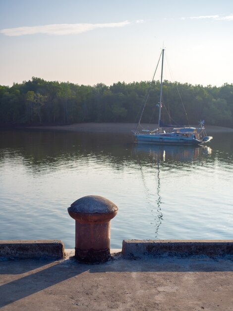 Premium Photo Old Bollard Without Mooring Rope On Concrete Port On Riverside With Yacht On The Sea On Mangrove Forest