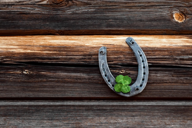 Premium Photo | Old horseshoe and four leaf clover on a vintage wooden ...