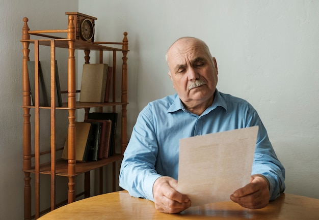 Premium Photo | Old man reading a paper document or letter