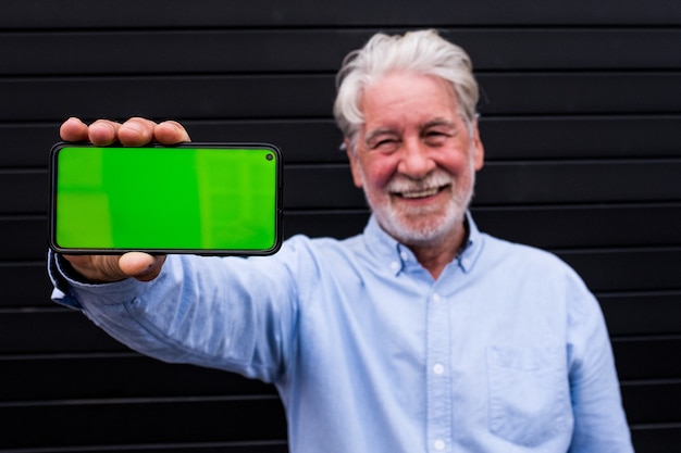 premium-photo-old-and-mature-man-holding-his-smartphone-showing-it-at