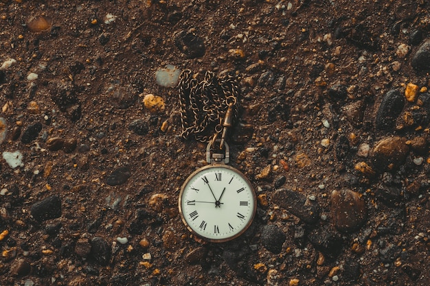 Premium Photo | Old pocket watch on the ground. the concept of the ...