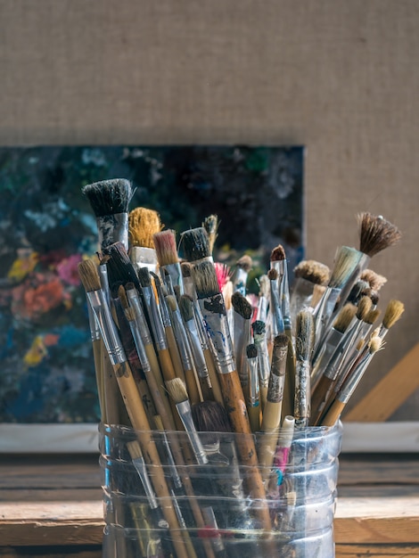 Premium Photo | Old used paint brushes in plastic bucket