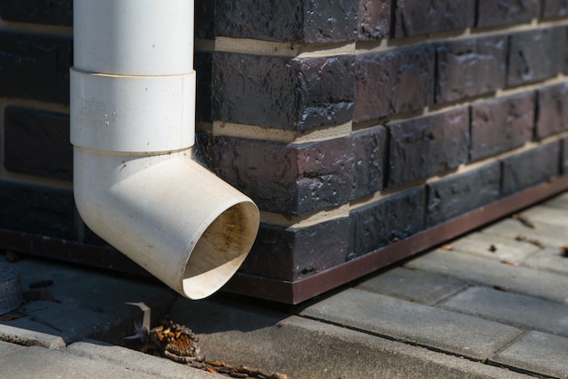 Premium Photo Old White Plastic Drain Pipe On The Brown Brick Wall Downspout