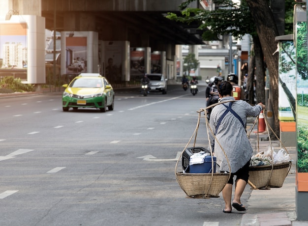 Premium Photo | Old woman hanking basket food sell on street