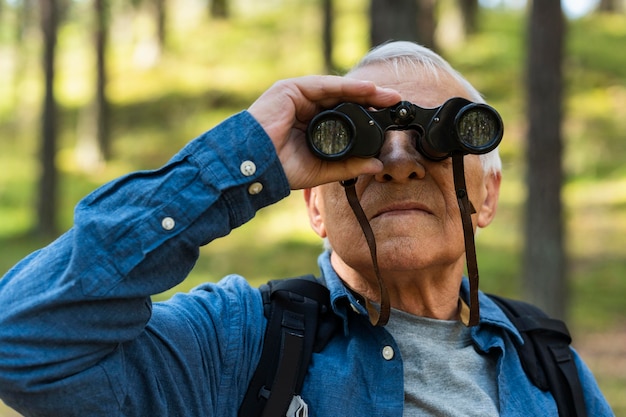 Free Photo | Older man exploring nature with binoculars