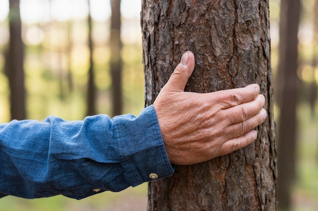 Free Photo Older Man Holding Tree While Backpacking