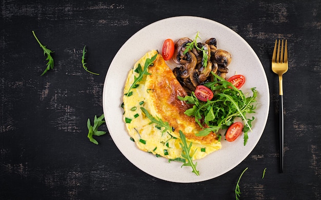 Premium Photo | Omelette with cheese, green herbs and fried mushrooms ...