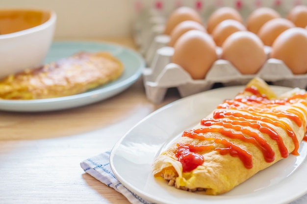 Omelette with ketchup on top in a white plate with a blur egg tray as a background Free Photo