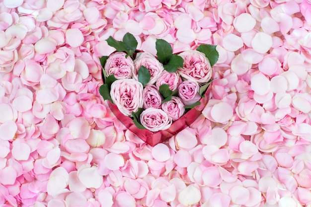ピンクのバラの花びらにハート型のギフトボックスにピンクのバラの花束 プレミアム写真