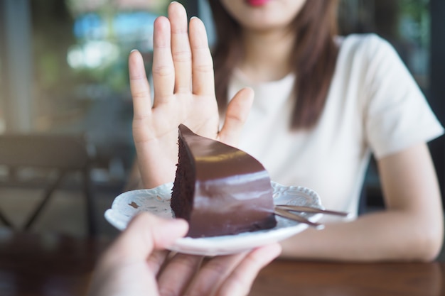 One of the health-care girls used a hand to push a plate of chocolate cake. Premium Photo