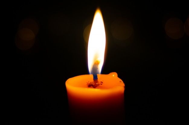 Premium Photo | One light candle burning brightly in the black background