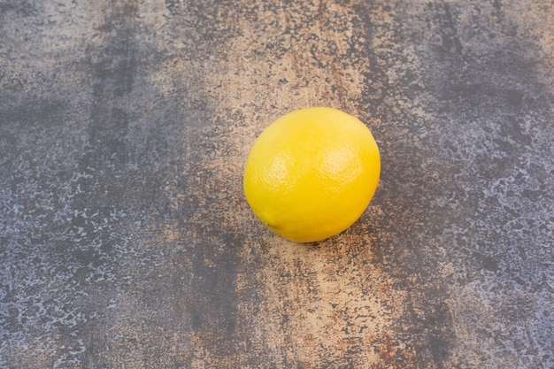 Free Photo | One whole lemons on stone surface