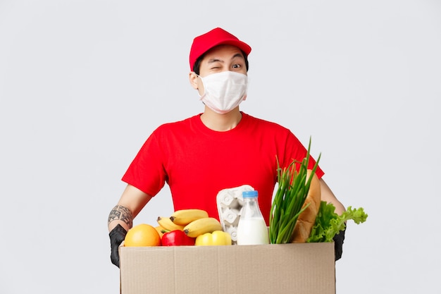 Online shopping, food delivery and coronavirus pandemic concept. asian delivery guy bring customer online shop order ...