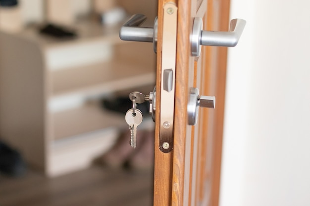 Open door with keys, key in keyhole, latch closeup | Premium Photo