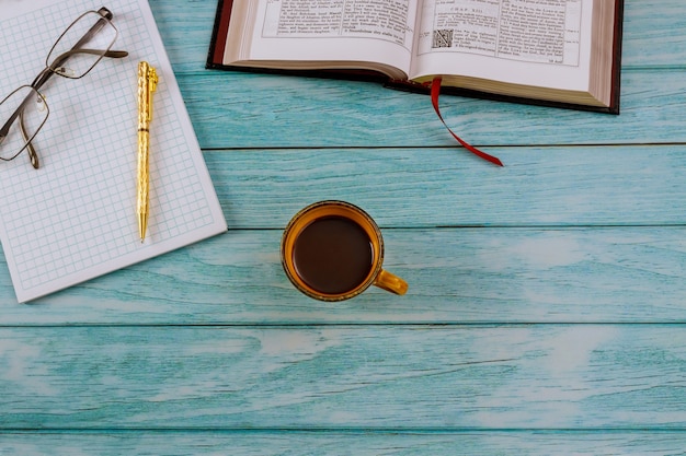 Premium Photo | Open holy bible lying on a wooden table in a reading ...