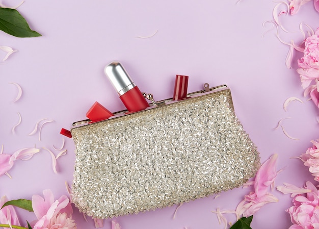 Open silver clutch and cosmetics fell out of the middle Premium Photo