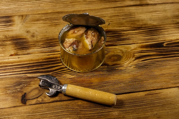 Premium Photo | Open tin can of sardine fish and can opener on wooden table