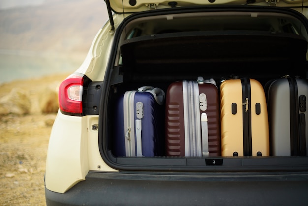 Opened car trunk full of suitcases, luggage, baggage. Premium Photo