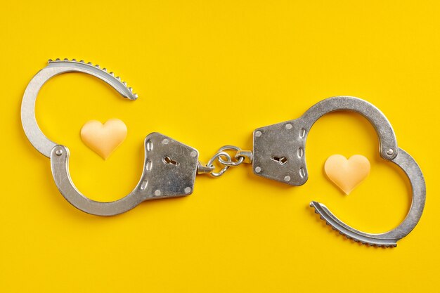 Premium Photo | Opened handcuffs on yellow background