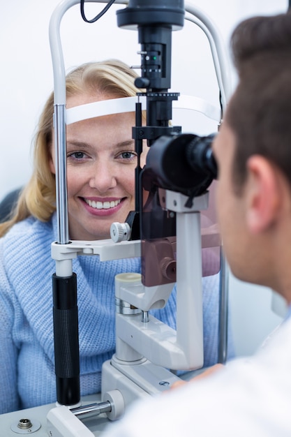 Premium Photo | Optometrist examining female patient on slit lamp