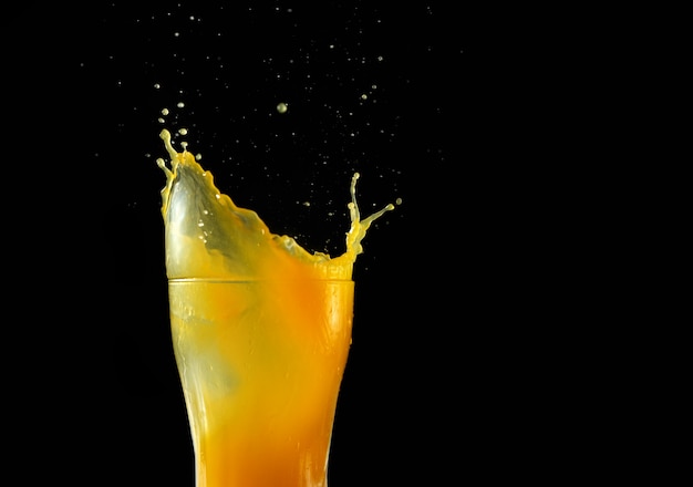 Premium Photo | Orange juice spills out of a glass